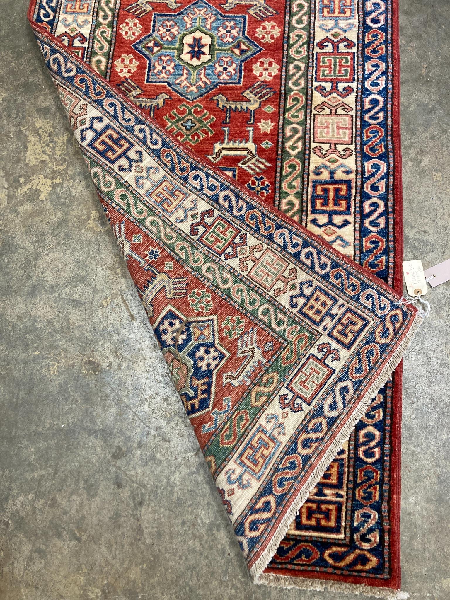 A Kazak red ground runner with geometric motifs, 274 x 80cm
